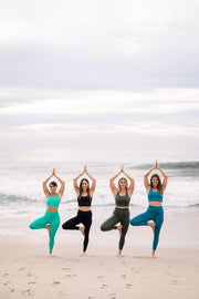 Yoga girls doing yoga at the beach while wearing  sustainable yoga clothing on different colors by Moonah Wear