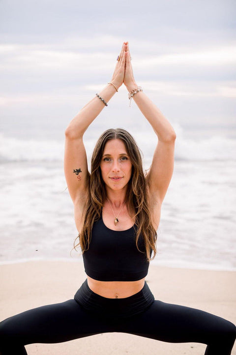Woman wearing black yoga top and black high waist yoga leggings 