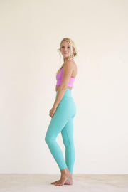 Yoga girl wearing super high waist mint yoga leggings and pink yoga top