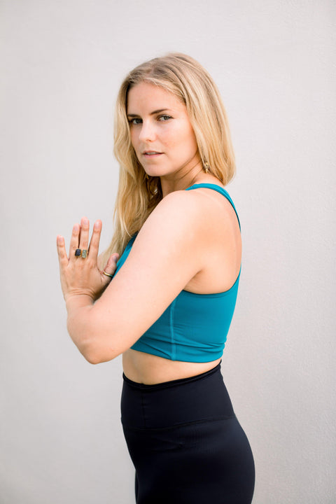 Eva Estlander wearing blue yoga top and black high waisted yoga leggings