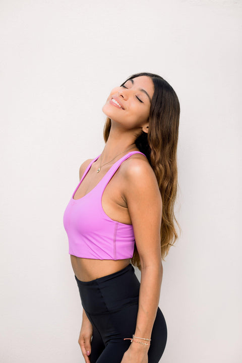 Yogini wearing sustainable pink yoga top and black leggings by Moonah Wear 